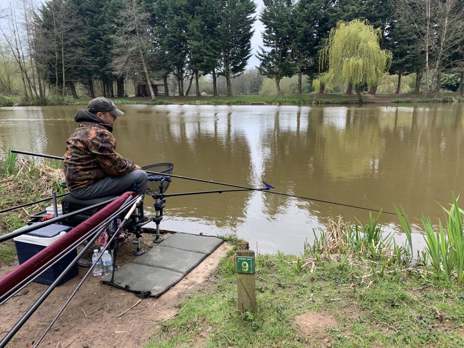 A man pole fishing on a lake