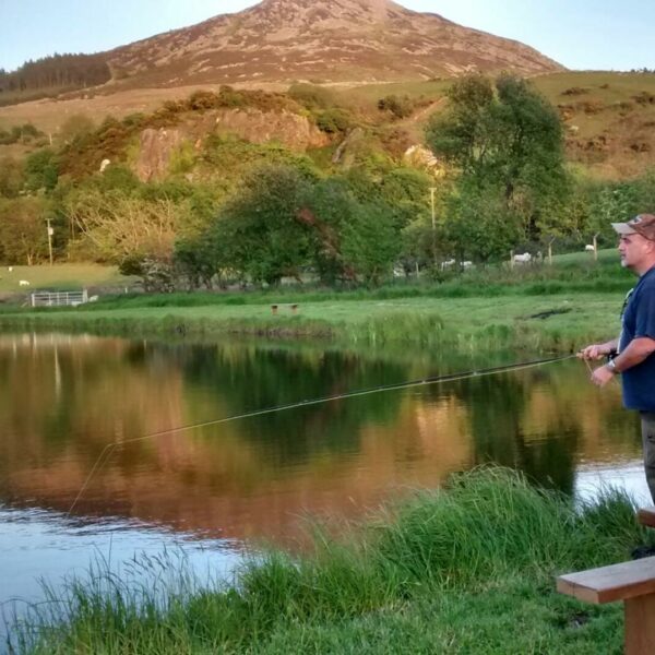 Fishing the lake at Ty Bwlcyn holiday cottage and glamping pods near Pwllheli in North Wales